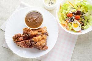 gefrituurde varkensschenkel met champignonjus bron, verse groente en salade crème bron foto