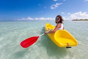 jonge blanke vrouw kajakken in zee op de Maldiven