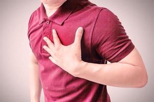 een volwassen man gebruikt zijn hand om zijn borst vast te houden. na een symptoom van een hartaanval. concepten van gezondheidszorg en medicijnen voor mannen. foto