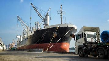 container laden in een vrachtschip met industriële kraan. containerschip in logistiek bedrijf voor import en export. industrie en transport concept. foto