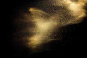 zandexplosie geïsoleerd op zwarte achtergrond. bevriezen beweging van zandige stof splash. foto