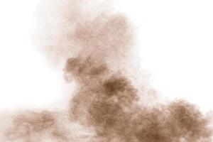 bruin poeder stof cloud.brown deeltjes spetterde op een witte achtergrond. foto