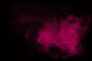 roze stofdeeltjes spatten op zwarte background.pink poeder splash. foto