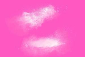 bevriezen beweging van witte deeltjes op roze achtergrond. abstracte witte stofexplosie. foto