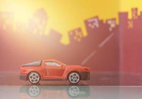 rode minivrachtwagen of pick-up auto speelgoed selectieve focus op wazige stadsachtergrond foto
