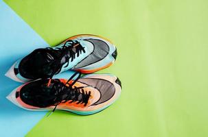 blauwe en oranje hardloopschoenen op groene vloer met kopieertestruimte foto