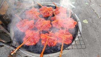 kip gegrild op houtskool heet, rook op kip. Thais straatvoedsel foto