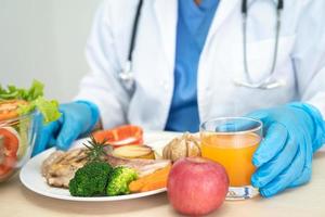 voedingsdeskundige arts met verschillende gezonde verse groenten voor de patiënt. foto