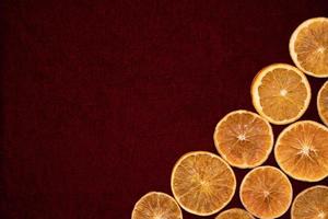 droge stukjes sinaasappel op rode achtergrond foto