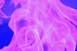 abstracte schittering van vlammen van roze licht op een blauwe achtergrond. foto