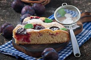 heerlijke zelfgemaakte cake met pruimen op een houten ondergrond foto