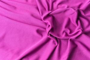 roze stof getextureerde achtergrond. sport roze kleding stof jersey structuur. foto