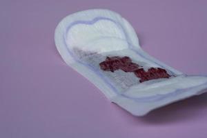 menstruatiebloed op een maandverband op roze achtergrond. plat leggen foto