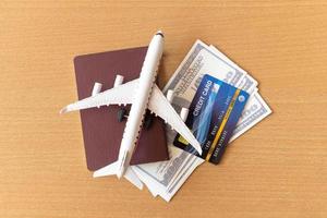 speelgoedvliegtuig, creditcards, dollars en paspoort op houten tafel. reisconcept foto