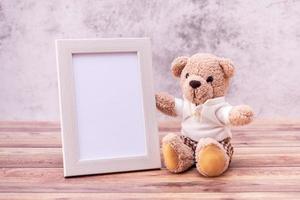 teddybeer met fotolijst op houten tafel. valentijnsdag viering foto