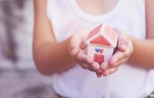 kleine kinderhanden die huis vasthouden foto