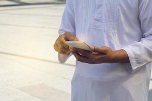 Arabische zakenmanberichten op een mobiele telefoon in de stad foto