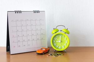 kalender en auto op tafel. dag van aan- of verkoop van een auto of betaling voor huur of lening of reparatie foto