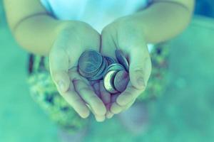 munt in de hand van kinderen. zakelijk en financieel concept foto