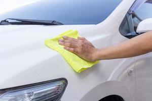 man die auto schoonmaakt met microvezeldoek foto