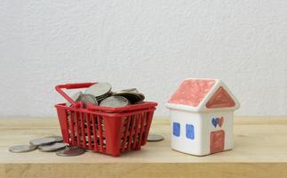 munten in een mand rood en huismodel voor geldconcept foto