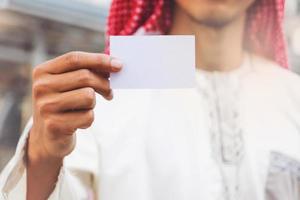 Arabische zakenmanhand die visitekaartje toont foto