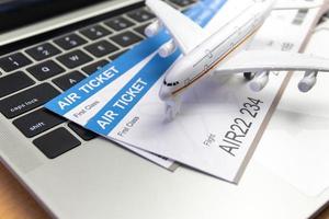 laptopcomputer en vliegtuig en geld op tafel. online ticketboekingsconcept foto