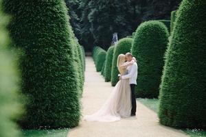 een trendy jong stel loopt in de zomer door de stad, de jonge vrouw draagt een luxe jurk foto