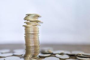 zaken, geld, financiën, veiligheid en besparingsconcept. close-up van onstabiele stapel munten op houten tafel met kopieerruimte. foto