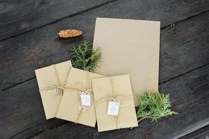 drie ambachtelijke enveloppen en een stuk ambachtelijk papier. plaats voor uw tekst en bericht. handgemaakte cadeauverpakking. foto