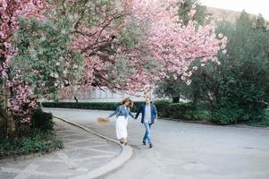 paar verliefd in een bloeiende appelboomgaard liggend op de deken foto