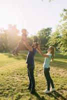 ouders spelen in het park met hun zoon foto