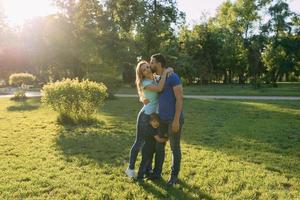 ouders spelen in het park met hun zoon foto