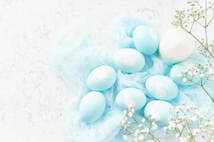 Pasen. vakantie. lichte witte achtergrond, zachte pastelkleuren. blauwe eieren met afbeelding van konijn foto