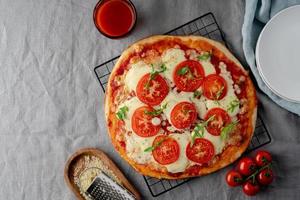 rustieke Italiaanse zelfgemaakte pizzadeeg margherita gegarneerd met pizzasaus en donkere achtergrond foto