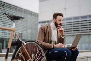 contemplatieve zakenman die buiten zit en nadenkt over het oplossen van een probleem. afstandswerk foto