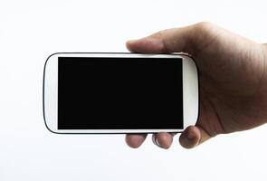 hand met witte smartphone geïsoleerd op een witte achtergrond. kopieer ruimteconcept foto