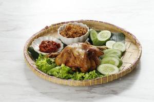 ayam goreng bakakak of hele gebakken kip, geserveerd met sambal en seroendeng foto