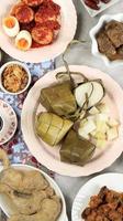 ketupat lebaran. traditioneel feestgerecht van rijstwafel of ketupat met verschillende bijgerechten, populair geserveerd tijdens eid-vieringen. foto