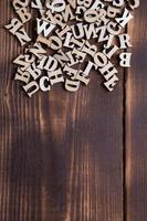 letters van het Engelse alfabet op een donkere houten achtergrond. het concept van onderwijs, woordspelletjes, handwerken. ruimte voor tekst foto