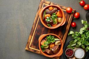 goulash met grote stukken rundvlees en groenten. donkerbruine achtergrond. bovenaanzicht, kopieer ruimte foto