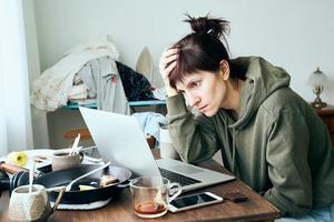 digitale verslaving, vrouw in paniek leest artikelen over coronavirus op internet. foto