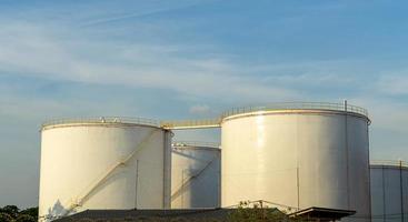 grote industriële tanks voor benzine en olie met blauwe sky.fuel-tanks op het tankpark. metalen trap aan de zijkant van een industriële oliecontainer. trap op grote brandstoftank foto