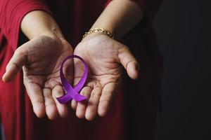 hand met paars lint voor de ziekte van alzheimer, alvleesklierkanker, epilepsiebewustzijn, wereldkankerdag foto