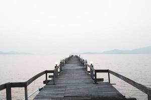 een houten loopbrug die zich uitstrekt in de zee. vakantie reisconcept foto