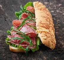 sandwich met salami, sla, tomaat en rucola foto