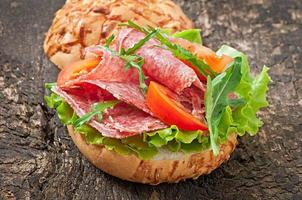 sandwich met salami, sla, tomaat en rucola foto