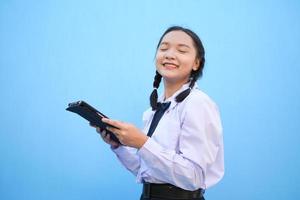 schoolmeisje met tablet op blauwe achtergrond. foto