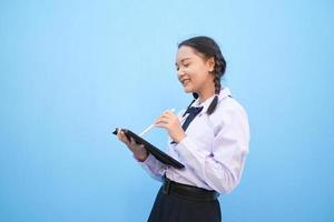 schoolmeisje met tablet op blauwe achtergrond. foto