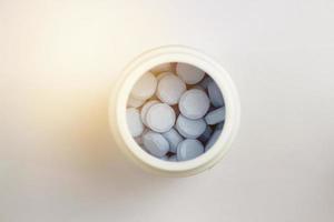 blauwe tabletten in witte plastic pot in drogisterijconcept voor medische gezondheidszorg, gesloten foto